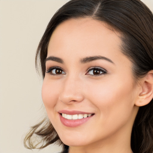 Joyful white young-adult female with long  brown hair and brown eyes