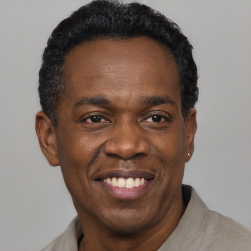 Joyful black adult male with short  black hair and brown eyes