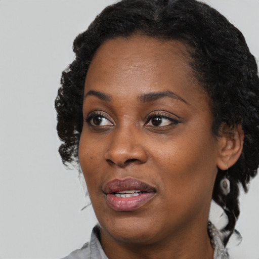 Joyful black young-adult female with medium  black hair and brown eyes