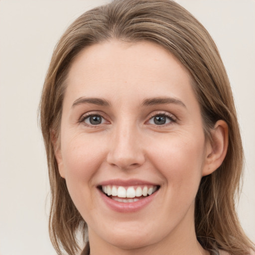 Joyful white young-adult female with medium  brown hair and grey eyes