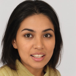 Joyful latino young-adult female with long  brown hair and brown eyes