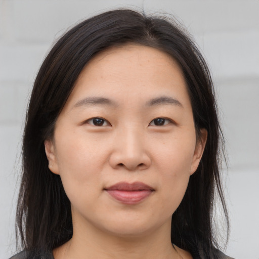 Joyful asian young-adult female with long  brown hair and brown eyes