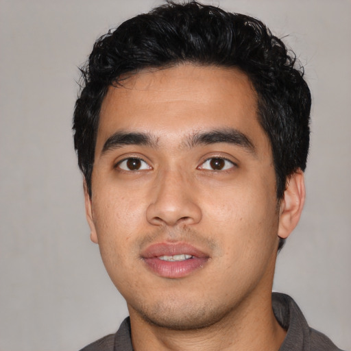 Joyful asian young-adult male with short  black hair and brown eyes