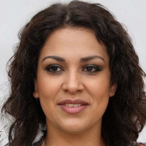 Joyful latino young-adult female with long  brown hair and brown eyes