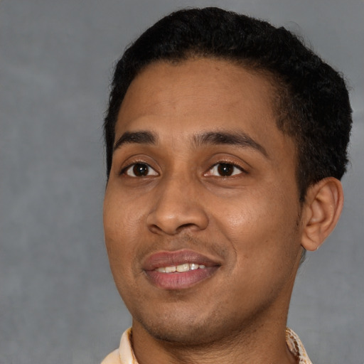 Joyful black young-adult male with short  black hair and brown eyes