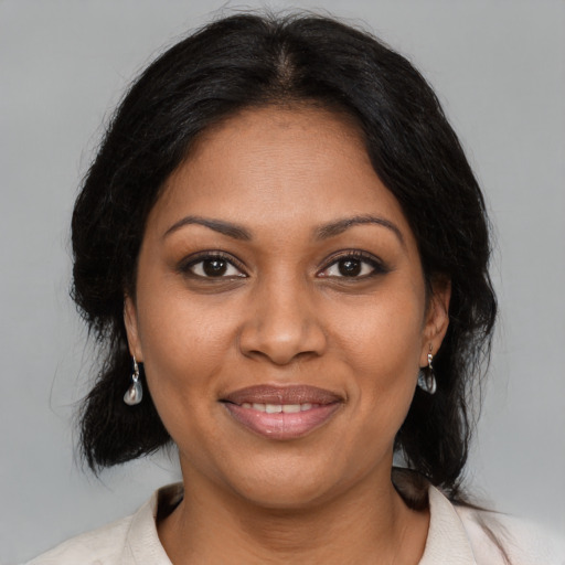 Joyful black adult female with medium  black hair and brown eyes