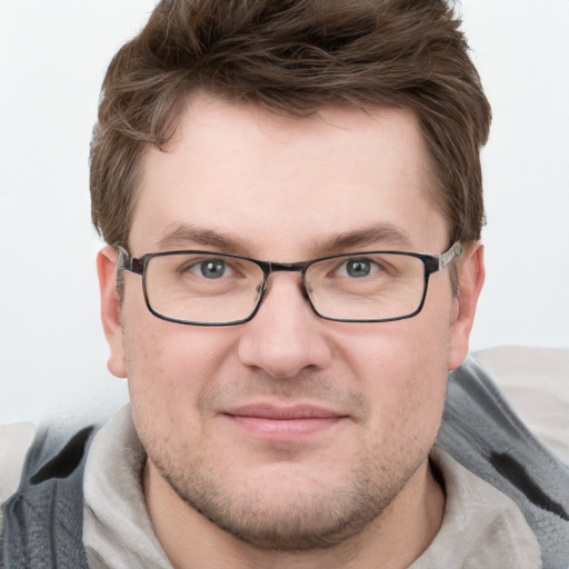 Joyful white young-adult male with short  brown hair and blue eyes