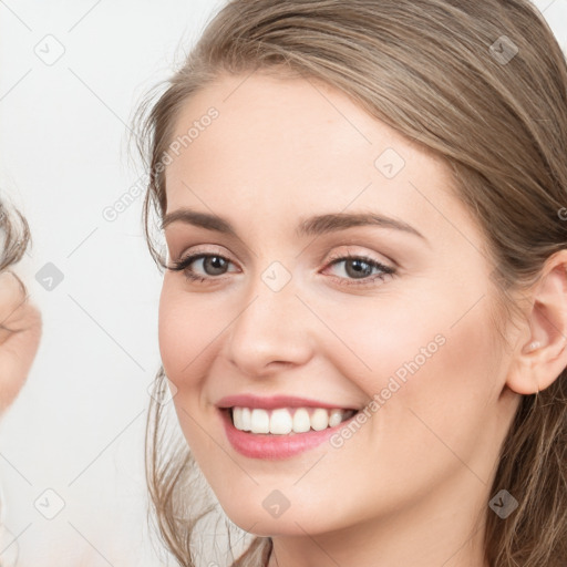 Joyful white young-adult female with long  brown hair and blue eyes