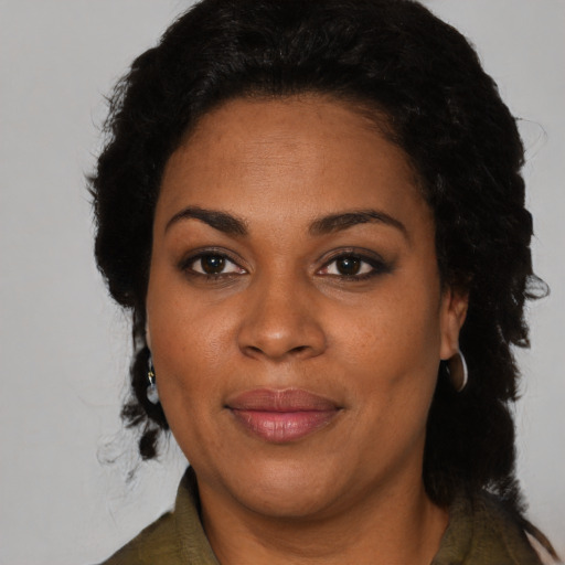 Joyful black young-adult female with medium  black hair and brown eyes