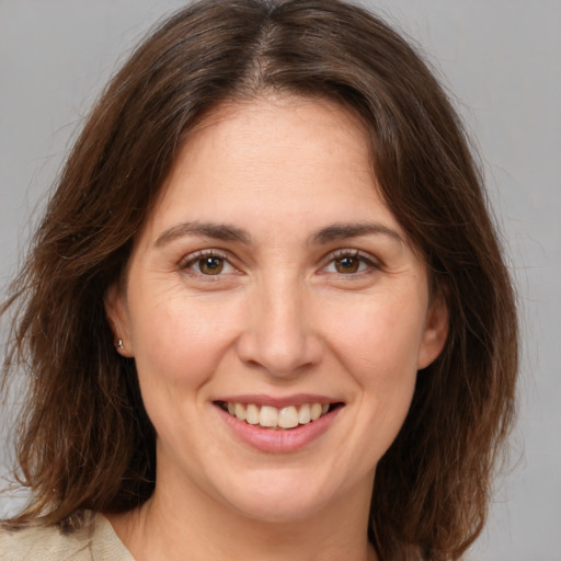 Joyful white adult female with medium  brown hair and brown eyes