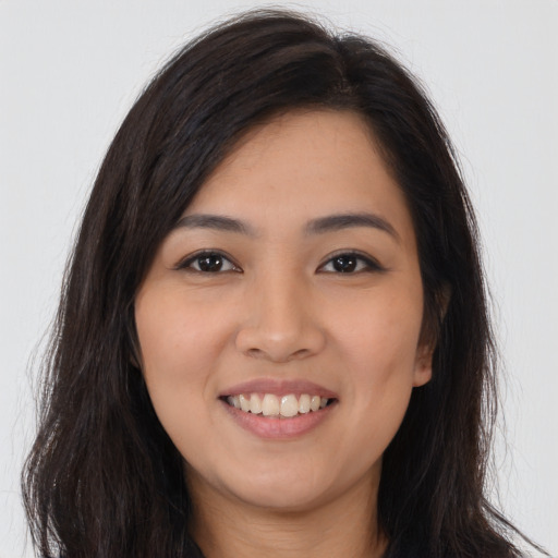 Joyful latino young-adult female with long  brown hair and brown eyes