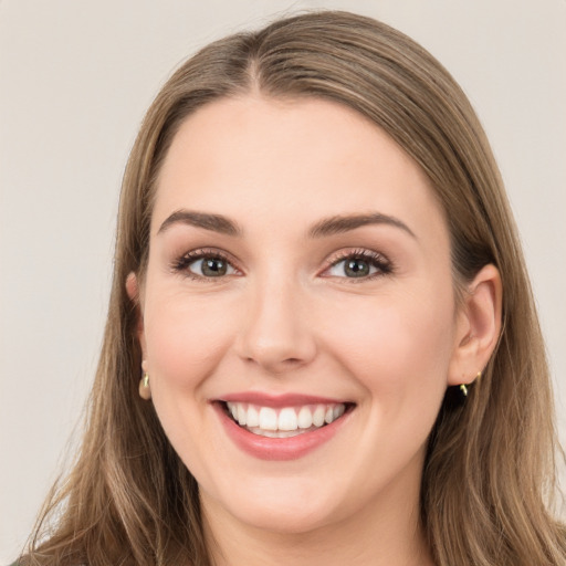 Joyful white young-adult female with long  brown hair and green eyes