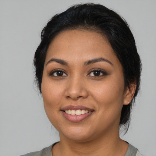 Joyful latino young-adult female with medium  black hair and brown eyes