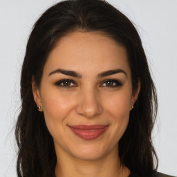 Joyful latino young-adult female with long  brown hair and brown eyes