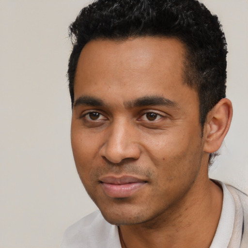 Joyful latino young-adult male with short  black hair and brown eyes