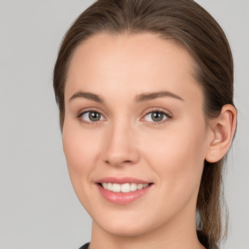 Joyful white young-adult female with long  brown hair and grey eyes