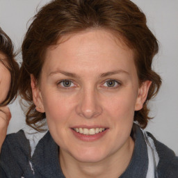 Joyful white young-adult female with medium  brown hair and blue eyes