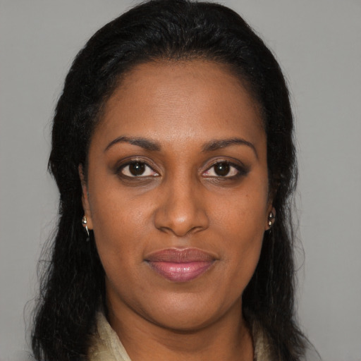 Joyful black young-adult female with long  brown hair and brown eyes
