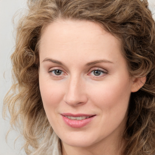 Joyful white young-adult female with medium  brown hair and blue eyes