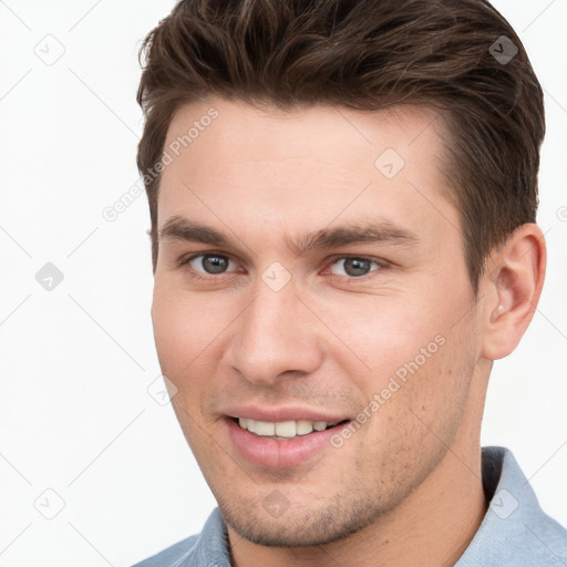 Joyful white young-adult male with short  brown hair and grey eyes