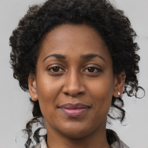 Joyful black adult female with long  brown hair and brown eyes