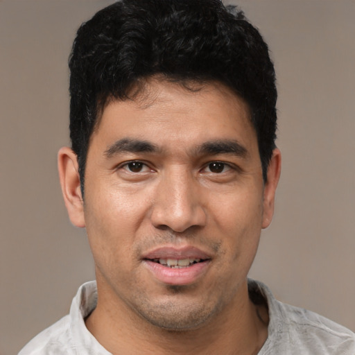 Joyful white young-adult male with short  black hair and brown eyes