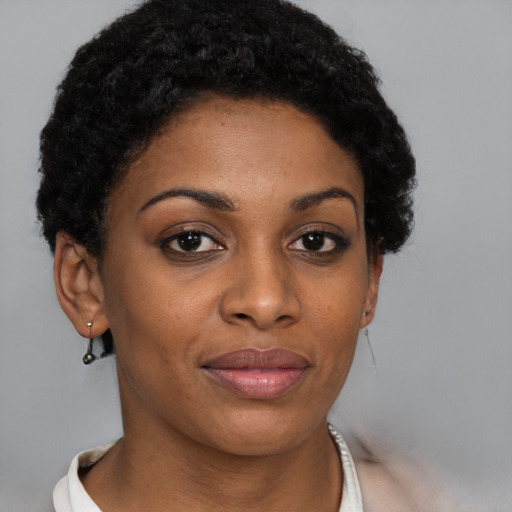 Joyful black young-adult female with short  brown hair and brown eyes