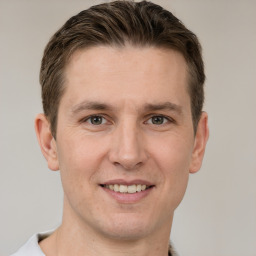 Joyful white young-adult male with short  brown hair and grey eyes