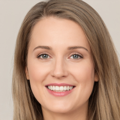 Joyful white young-adult female with long  brown hair and grey eyes