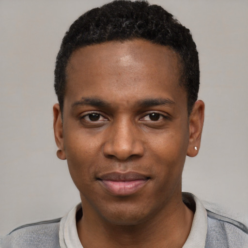 Joyful black young-adult male with short  black hair and brown eyes