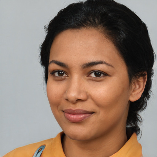 Joyful latino young-adult female with medium  brown hair and brown eyes