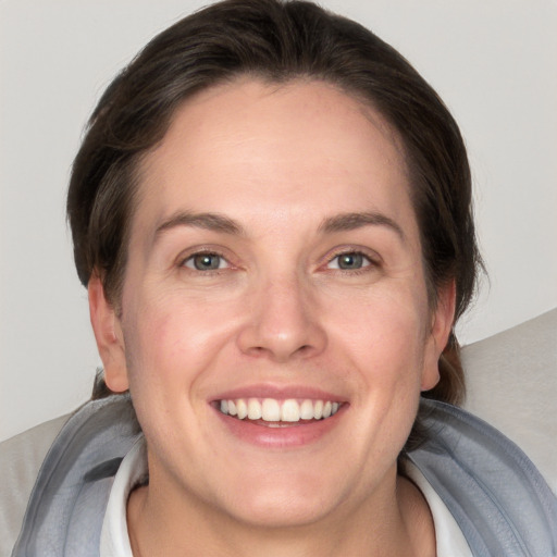 Joyful white adult female with short  brown hair and grey eyes