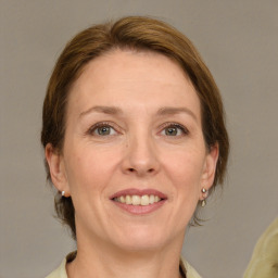 Joyful white adult female with medium  brown hair and grey eyes