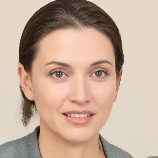 Joyful white young-adult female with medium  brown hair and grey eyes