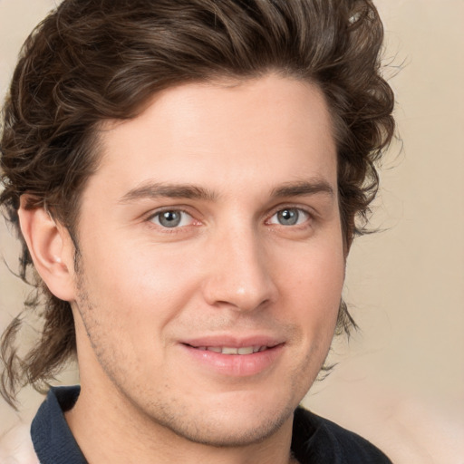 Joyful white young-adult male with medium  brown hair and grey eyes