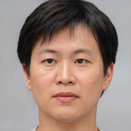 Joyful asian adult male with short  brown hair and brown eyes