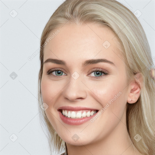 Joyful white young-adult female with long  brown hair and blue eyes