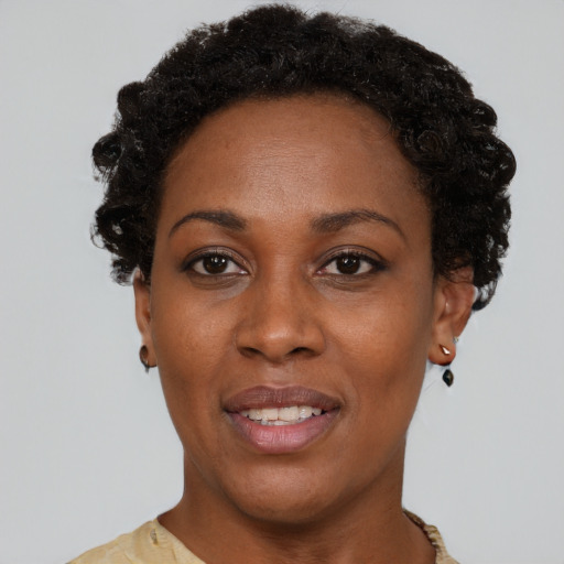 Joyful black young-adult female with short  brown hair and brown eyes