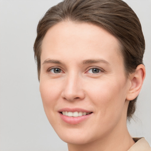 Joyful white young-adult female with short  brown hair and grey eyes