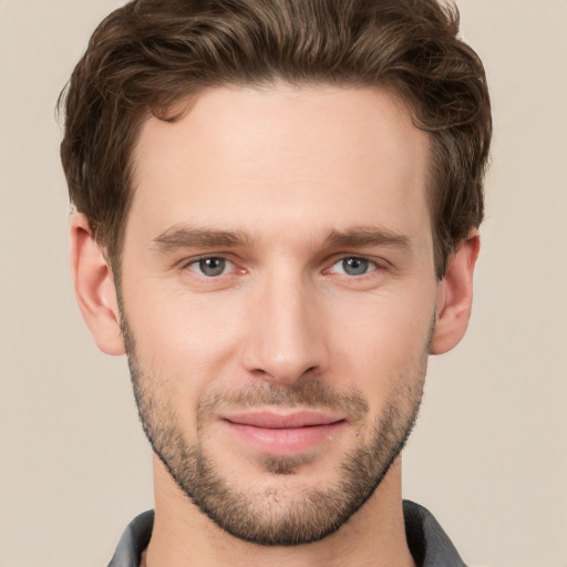 Joyful white young-adult male with short  brown hair and grey eyes