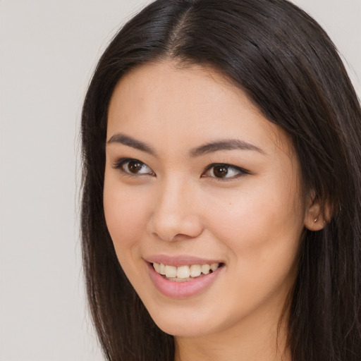 Joyful asian young-adult female with long  brown hair and brown eyes