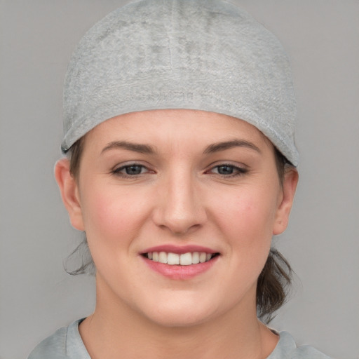 Joyful white young-adult female with short  brown hair and blue eyes