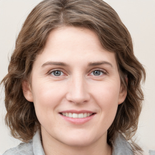 Joyful white young-adult female with medium  brown hair and blue eyes