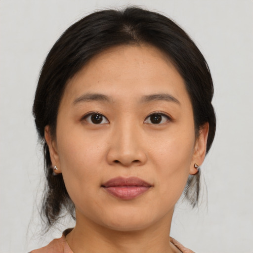 Joyful asian young-adult female with medium  brown hair and brown eyes