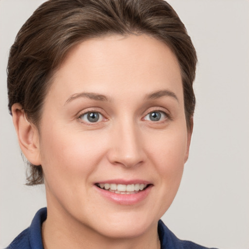 Joyful white young-adult female with short  brown hair and grey eyes