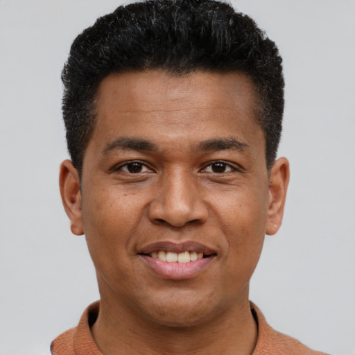 Joyful latino young-adult male with short  brown hair and brown eyes
