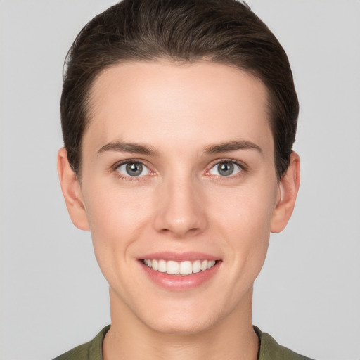 Joyful white young-adult female with short  brown hair and grey eyes