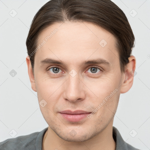 Joyful white young-adult male with short  brown hair and grey eyes