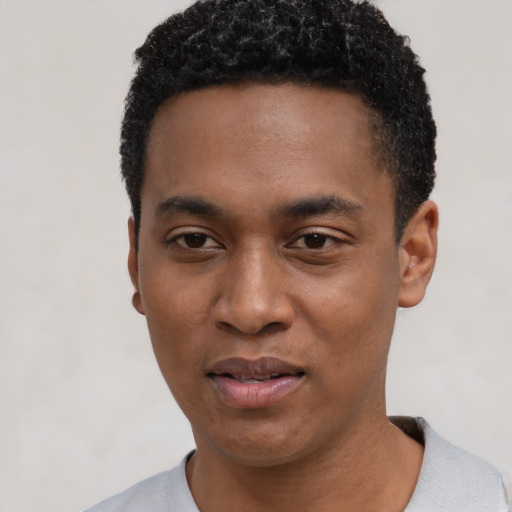 Joyful black young-adult male with short  black hair and brown eyes