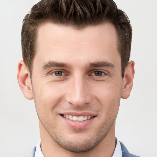 Joyful white young-adult male with short  brown hair and grey eyes